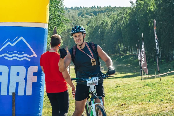 Mayıs 26-27, 2018 Naliboki, Beyaz Rusya All-Belarusça amatör maraton Naliboki A man ve boynunda bir madalya ile bir bisiklet ile standları şişirilebilir kemer oteller