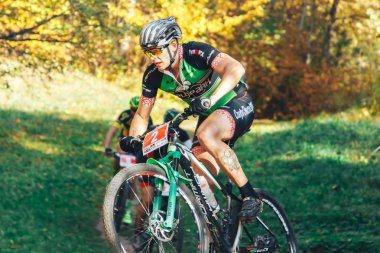 14 Ekim 2018, Minsk, Belarus.2018 Olimpik Kros Kupası XCO Medvezhino 'da Orman yolunda bisiklet süren bir adam