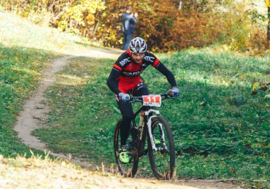 14 Ekim 2018, Minsk, Belarus.2018 Olimpik Kros Kupası XCO Medvezhino 'da Orman yolunda bisiklet süren bir adam