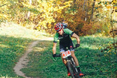 14 Ekim 2018, Minsk, Belarus.2018 Olimpik Kros Kupası XCO Medvezhino 'da Orman yolunda bisiklet süren bir adam