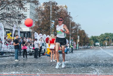 9 Eylül 2018 Minsk Belarus Yarı Maratonu Minsk 2018 Yol boyunca koşan bir adam Man finiş çizgisini geçiyor Konfeti havada uçuyor