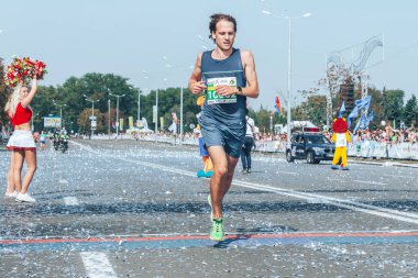 9 Eylül 2018 Minsk Belarus Yarı Maratonu Minsk 2018 Yol boyunca koşan bir adam Man finiş çizgisini geçiyor Konfeti havada uçuyor