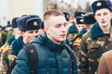 23 Şubat 2019 Minsk Belarus 23 Şubat'ta tatil onuruna yarış Kadın sokakta insanlar arasında bir adamın yanında telefona bakar