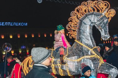 Kasaba meydanında 30 Aralık 2018 Minsk Beyaz Rusya yeni yıl kutlamaları. Küçük kız üzerinde parlayan bir atın üzerinde oturanbir