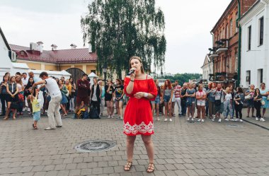 21 Temmuz 2018, Minsk, Beyaz Rusya Street yürüyüş kadın bir mikrofon ile bir sokak konserde söylüyor