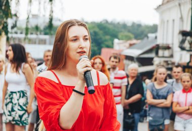 21 Temmuz 2018, Minsk, Beyaz Rusya Street yürüyüş kadın bir mikrofon ile bir sokak konserde söylüyor