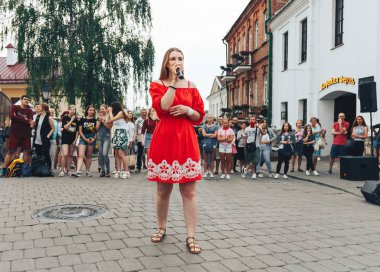 21 Temmuz 2018, Minsk, Beyaz Rusya Street yürüyüş kadın bir mikrofon ile bir sokak konserde söylüyor