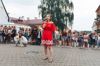 21 Temmuz 2018, Minsk, Beyaz Rusya Street yürüyüş kadın bir mikrofon ile bir sokak konserde söylüyor