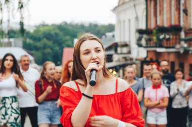 21 Temmuz 2018, Minsk, Beyaz Rusya Street yürüyüş kadın bir mikrofon ile bir sokak konserde söylüyor