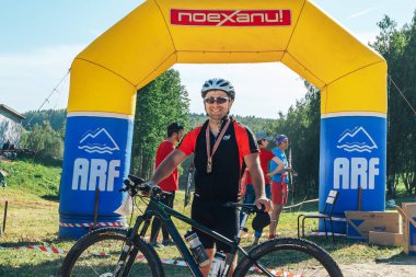 26-27 Mayıs 2018 Naliboki,Belarus Tüm Belarus amatör maratonu Naliboki Bisikletli bir adam finişte madalyalı duruyor