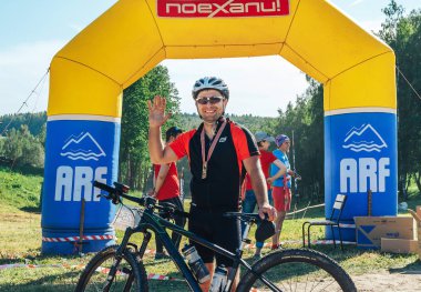 26-27 Mayıs 2018 Naliboki,Belarus Tüm Belarus amatör maratonu Naliboki Bisikletli bir adam finişte madalyalı duruyor