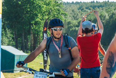 26-27 Mayıs 2018 Naliboki,Belarus Tüm Belarus amatör maratonu Naliboki Bisikletli bir adam finişte madalyalı duruyor