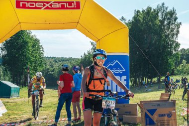 26-27 Mayıs 2018 Naliboki,Belarus Tüm Belarus amatör maratonu Naliboki Bisikletli bir kadın finişte madalyalı duruyor