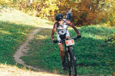 14 Ekim 2018, Minsk, Belarus.2018 Olimpik Kros Kupası XCO Medvezhino 'da Orman yolunda bisiklet süren bir adam