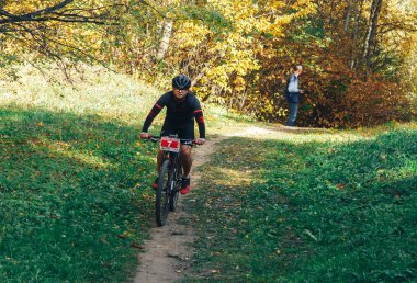 14 Ekim 2018, Minsk, Belarus.2018 Olimpik Kros Kupası XCO Medvezhino 'da Orman yolunda bisiklet süren bir adam