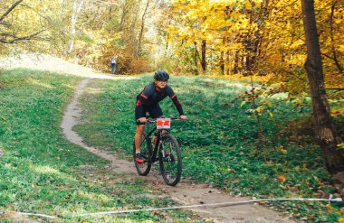 14 Ekim 2018, Minsk, Belarus.2018 Olimpik Kros Kupası XCO Medvezhino 'da Orman yolunda bisiklet süren bir adam