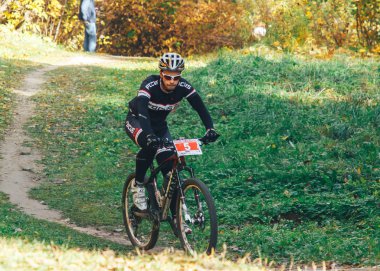 14 Ekim 2018, Minsk, Belarus.2018 Olimpik Kros Kupası XCO Medvezhino 'da Orman yolunda bisiklet süren bir adam