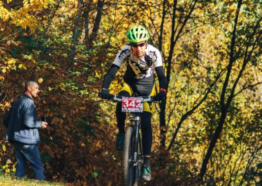 14 Ekim 2018, Minsk, Belarus.2018 Olimpik Kros Kupası XCO Medvezhino 'da Orman yolunda bisiklet süren bir adam