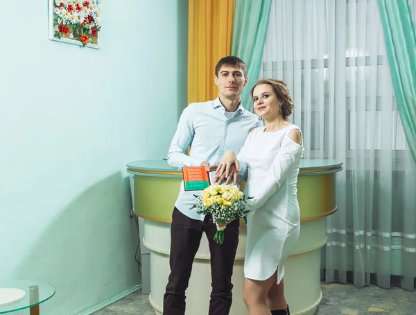 O noivo na camisa e a noiva em um vestido branco com documentos de casamento — Fotografia de Stock