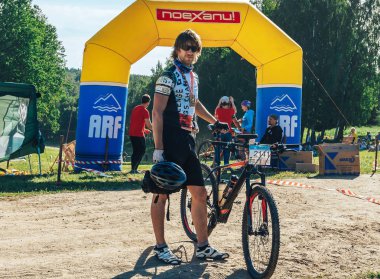 26-27 Mayıs 2018 Naliboki,Belarus Tüm Belarus amatör maratonu Naliboki Bisikletli bir adam finişte madalyalı duruyor