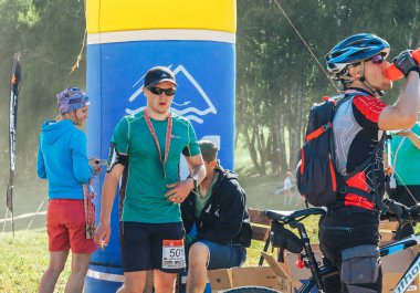 26-27 Mayıs 2018 Naliboki,Belarus Tüm Belarus amatör maratonu Naliboki Madalyalı bir adam finale koşuyor. Bir bisikletçi su içer.