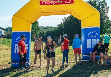 26-27 Mayıs 2018 Naliboki,Belarus Tüm Belarus amatör maratonu Naliboki Madalyalı bir kadın ve çıplak gövdeli bir adam, bitişte şişme kemerden geçiyor