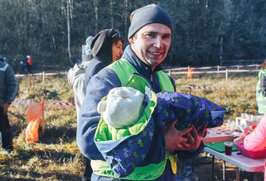 17 Kasım 2018 Logoisk Belarus Beetle-trail 8 Logoisk Bir adam ormanın yakınında kollarında küçük bir çocuk ile duruyor