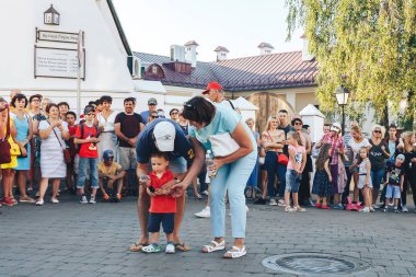 4 Ağustos 2018 Akşam kentte ki sokak şenlikleri baba küçük oğluna elinde mikrofon veriyor annesinin yanında insanların önünde meydanda bir adam çocuğuyla bir sokak konserinde sahne alıyor