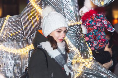 30 Aralık 2018 Minsk Belarus Yeni Yıl kutlamaları şehir meydanında. Genç bir kız bir sokak yürüyüşü sırasında parlayan bir rakam yanında duruyor