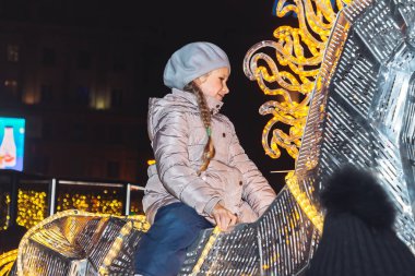 Kasaba meydanında 30 Aralık 2018 Minsk Beyaz Rusya yeni yıl kutlamaları. Küçük kız üzerinde parlayan bir atın üzerinde oturanbir