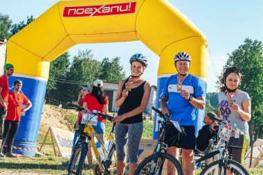 26-27 Mayıs 2018 Naliboki,Belarus Tüm Belarus amatör maratonu Naliboki. İki kadın ve bir adam şişme kemer yanında bisiklet yanında madalya ile standı
