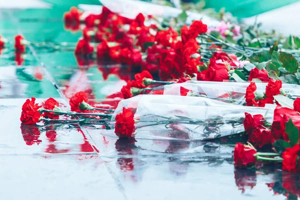 Rosas rojas yacen en el granito negro — Foto de Stock