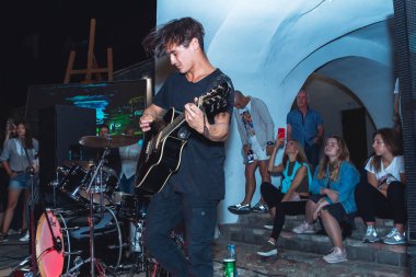 1 Eylül 2018 Akşam şehrinde Minsk Belarus Caddesi şenlikleri Bir adam bir sokak konserinde oturan kızların önünde gitar çalıyor