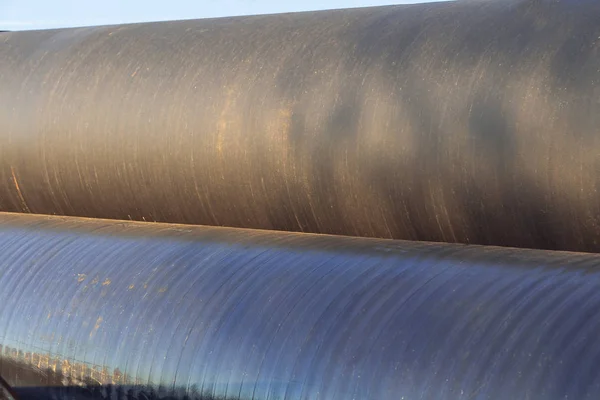 Metalen buizen met grote diameter voor de watertoevoer liggen op opslagplaatsen onder een open lucht — Stockfoto