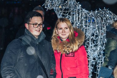 29 Aralık 2018 Akşam şehrinde Minsk Belarus Caddesi şenlikleri Bir erkek ve bir kadın parlayan bir figürün yanında duruyor.
