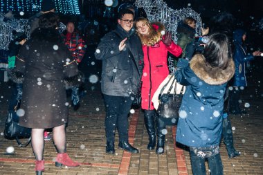 29 Aralık 2018 Akşam kentte Minsk Belarus Caddesi şenlikleri Bir kız telefonda bir erkek ve parlayan bir figür yakınında bir kadın fotoğrafları.