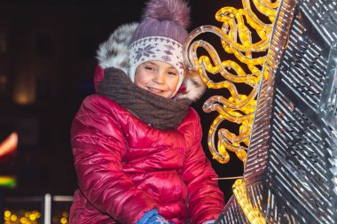 30 Aralık 2018 Minsk Belarus Yeni Yıl kutlamaları şehir meydanında. Küçük kız oturur ve parlayan bir at üzerinde tutar Close up