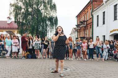 21 Temmuz 2018, Minsk, Beyaz Rusya Street yürüyüş kadın bir mikrofon ile bir sokak konserde söylüyor