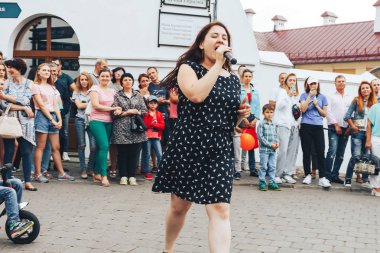 21 Temmuz 2018, Minsk, Beyaz Rusya Street yürüyüş kadın bir mikrofon ile bir sokak konserde söylüyor