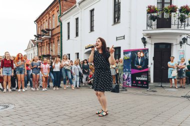 21 Temmuz 2018, Minsk, Beyaz Rusya Street yürüyüş kadın bir mikrofon ile bir sokak konserde söylüyor