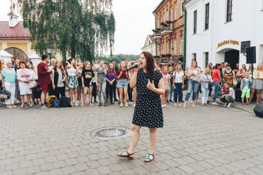 21 Temmuz 2018, Minsk, Beyaz Rusya Street yürüyüş kadın bir mikrofon ile bir sokak konserde söylüyor