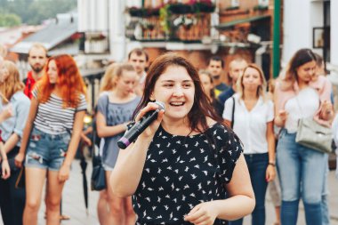 21 Temmuz 2018, Minsk, Beyaz Rusya Street yürüyüş kadın bir mikrofon ile bir sokak konserde söylüyor