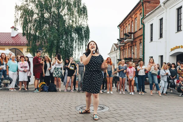 21 Temmuz 2018, Minsk, Beyaz Rusya Street yürüyüş kadın bir mikrofon ile bir sokak konserde söylüyor