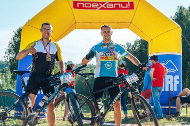 26-27 Mayıs 2018 Naliboki,Belarus Tüm Belarus amatör maratonu Naliboki İki bisikletçi bisiklet ve boyunlarında bir madalya şişme kemer in yanında duruyor.