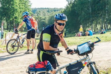 26-27 Mayıs 2018 Naliboki,Belarus Tüm Belarus amatör maratonu Naliboki Bir bisikletçi bisiklet ve boynunda madalya ile orman yakınında duruyor