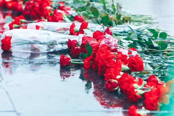 Red roses lie on the black granite — Stock Photo, Image