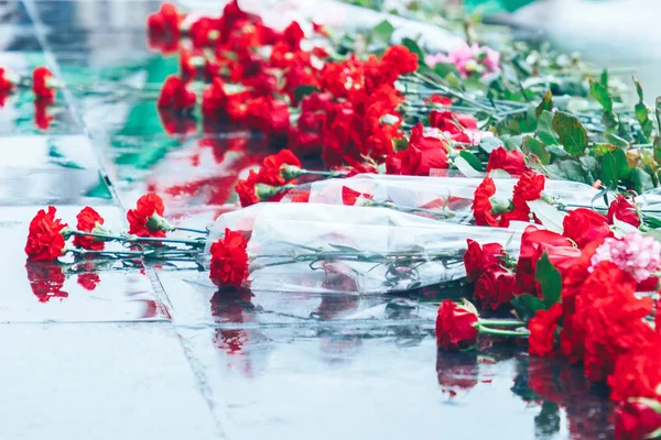 Rosas rojas yacen en el granito negro — Foto de Stock