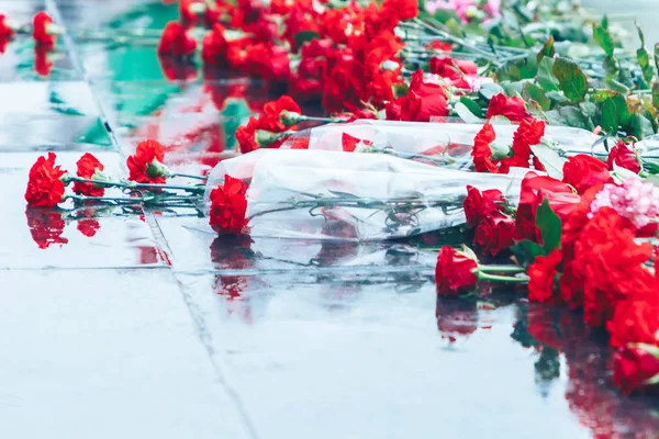 Rosas rojas yacen en el granito negro — Foto de Stock