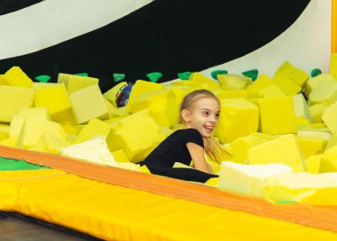 Genç güzel kız köpük küplerin içinde yatıyor.