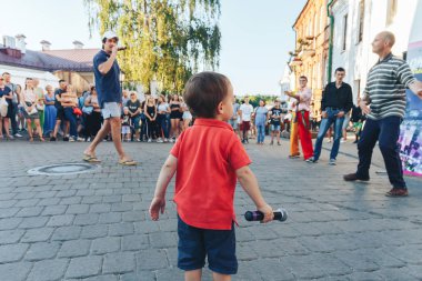 4 Ağustos 2018 Akşam kentte sokak şenlikleri Mikrofonlu küçük bir çocuk bir sokak konserinde insanlara bakıyor